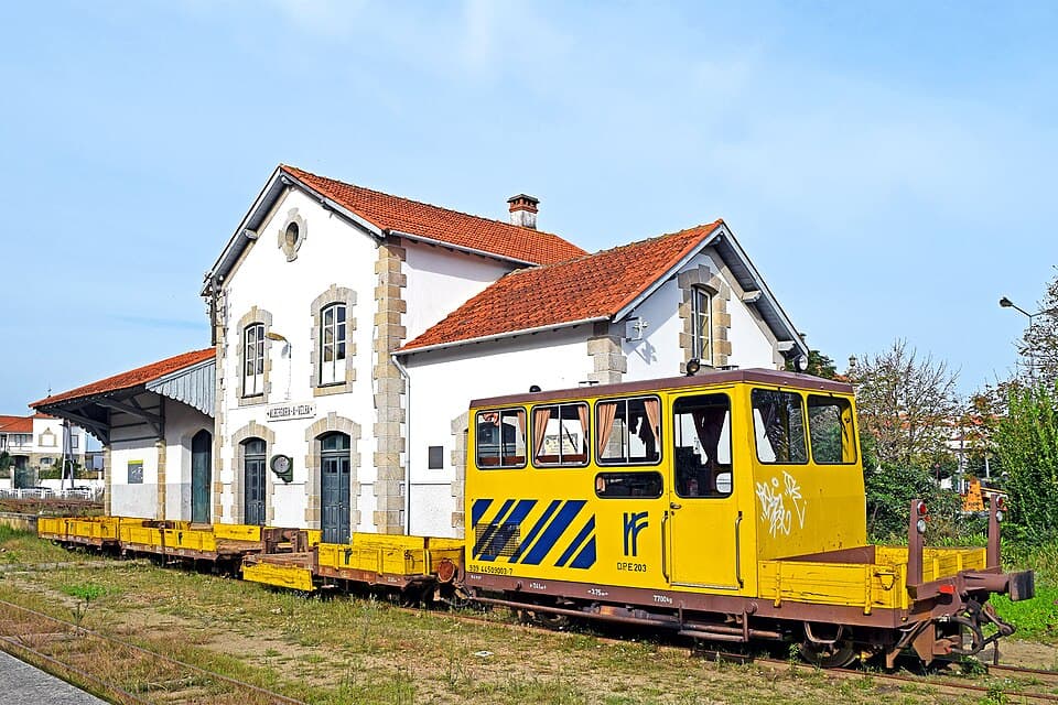 Edifício da estação e veículo amarelo da Linha do Vouga, em Albergaria-a-Velha