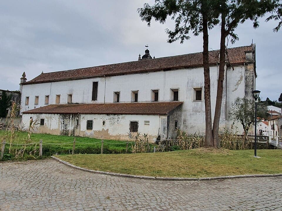 Edifício branco do antigo Mosteiro de Coz junto ao adro