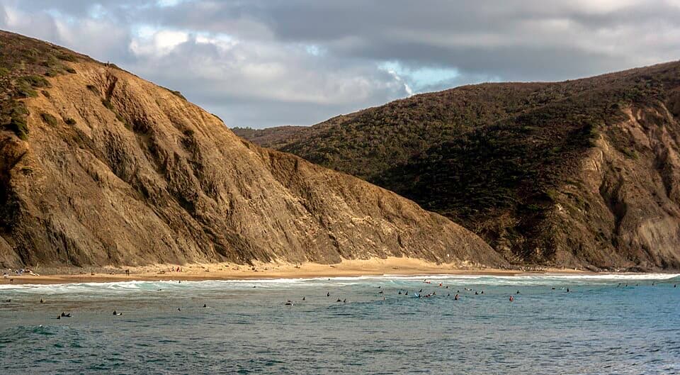 Enseada da Praia da Arrifana entre arribas escuras