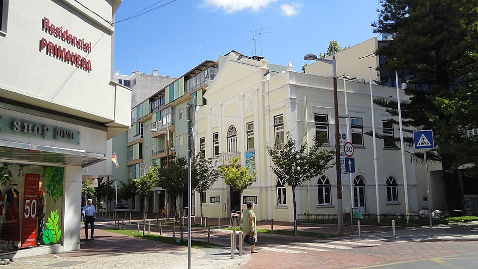 Fachada clara dos Recreios da Amadora numa rua pedonal