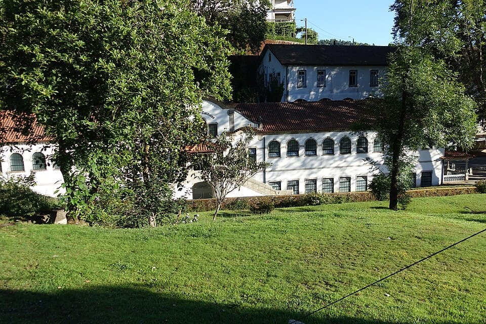 Edifício branco das Termas de Caldelas entre árvores e relvado