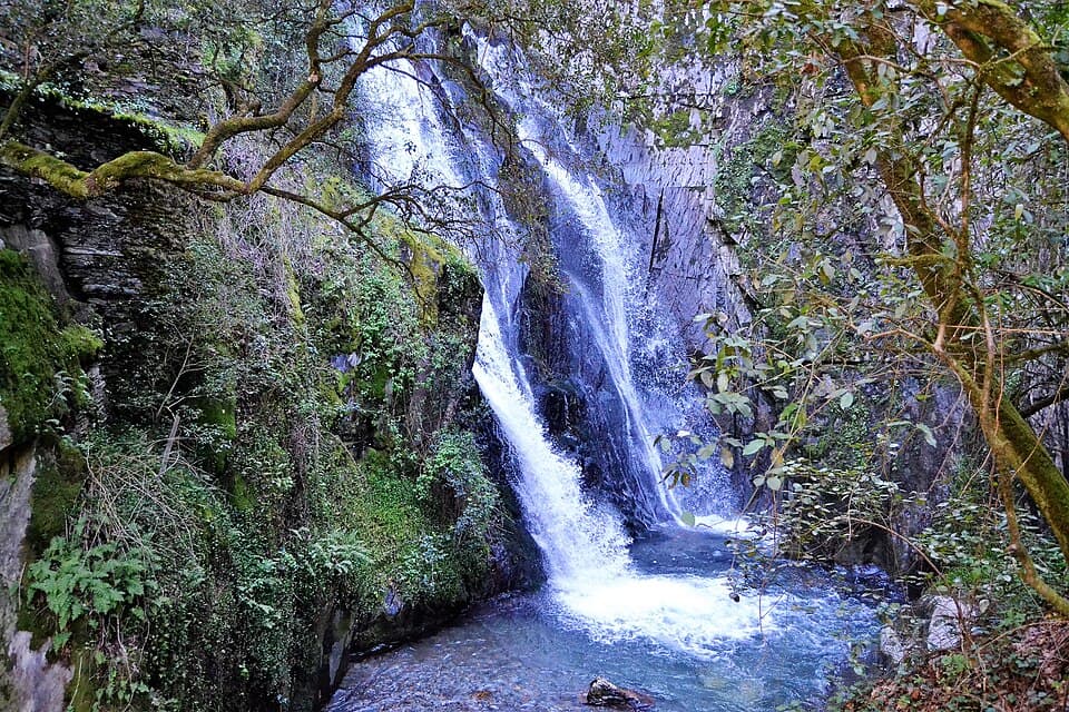 Cascata da Fraga da Pena entre rocha e vegetação densa