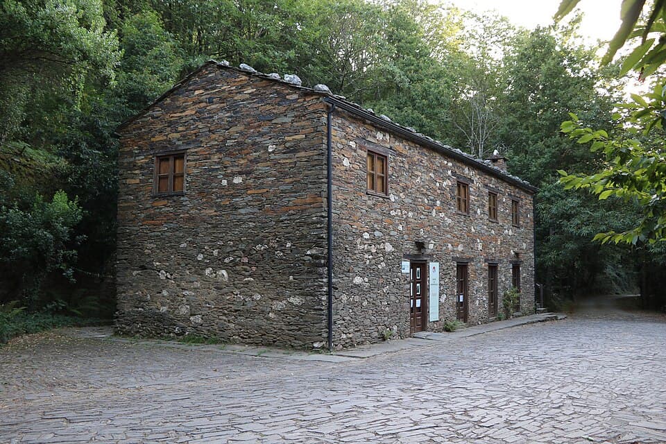 Casa de xisto e pedra entre o arvoredo da Mata da Margaraça