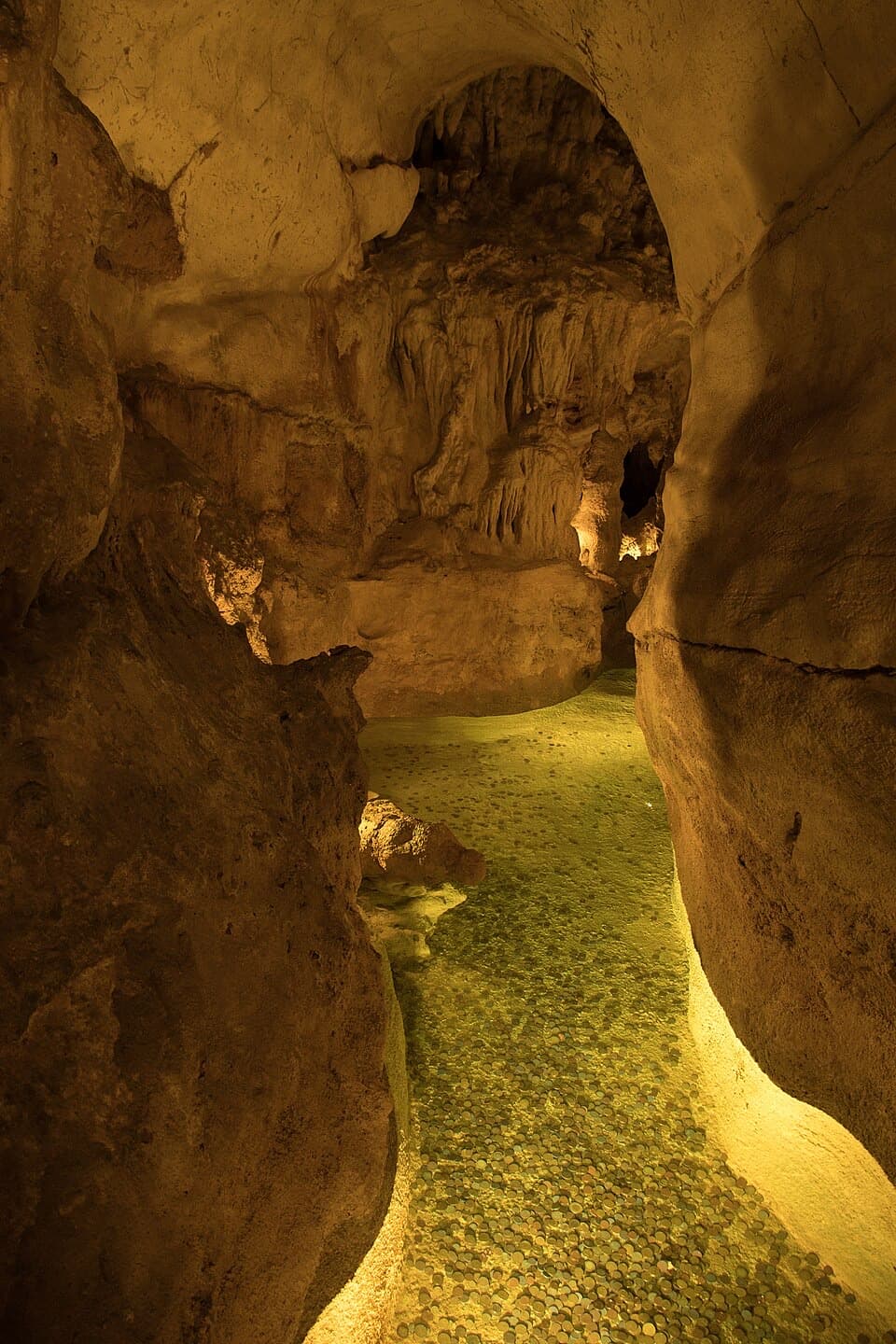 Galeria iluminada e formações calcárias no interior das Grutas da Moeda