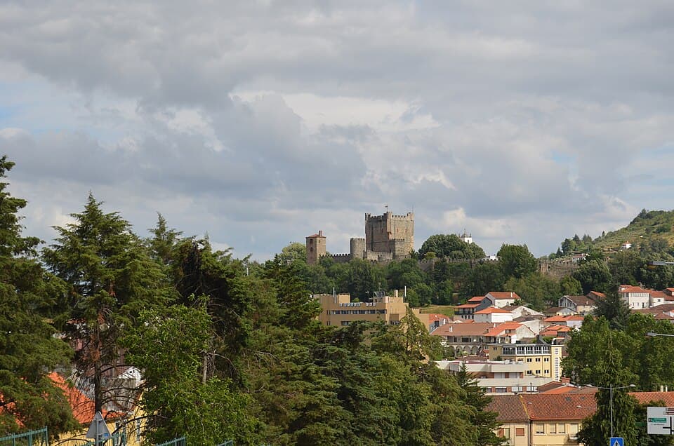 Castelo de Bragança elevado sobre os telhados e o arvoredo da cidade
