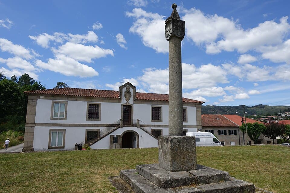 Pelourinho de Cabeceiras de Basto diante de um edifício histórico em Refojos