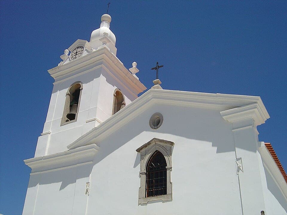 Torre, relógio e fachada branca da Igreja Matriz do Cadaval