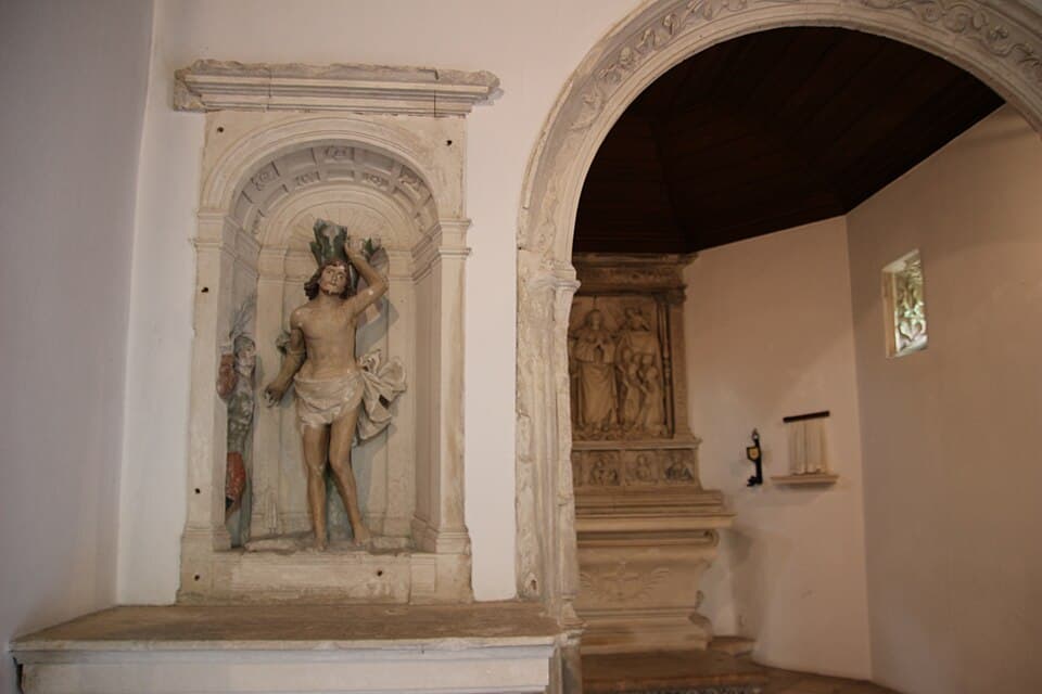 Escultura em pedra e arco no interior da Capela da Varziela, em Cantanhede