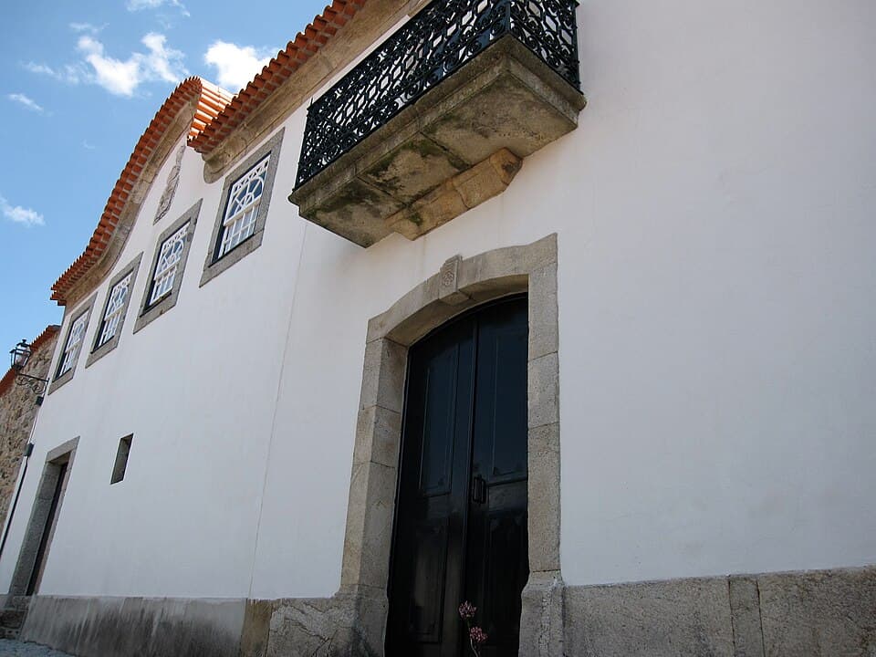 Fachada branca, portal e varanda de ferro do Solar dos Pinas