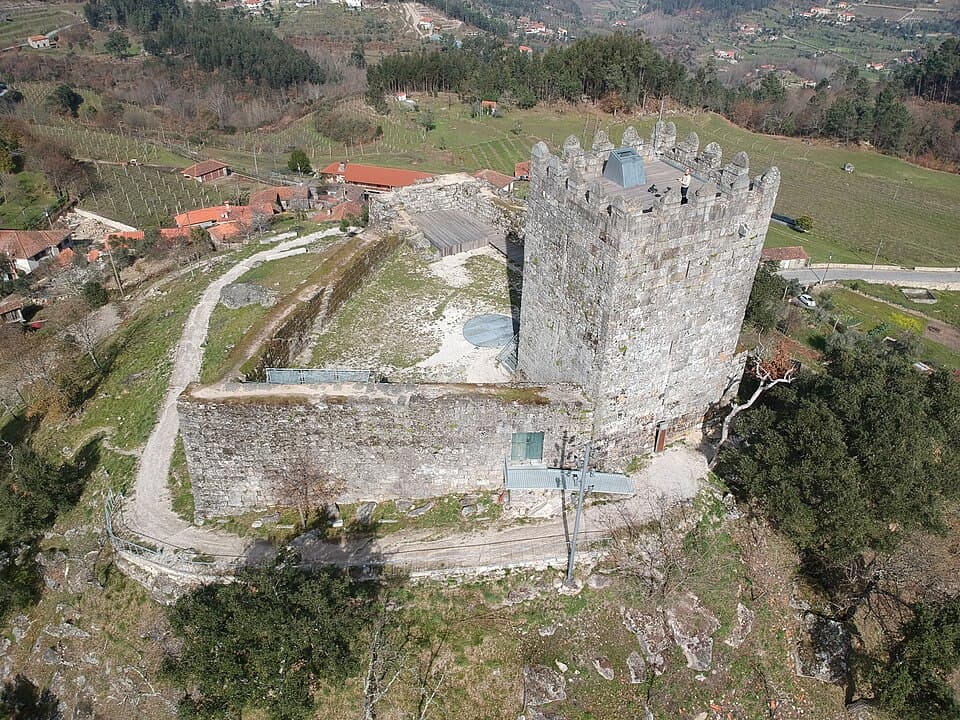 Vista aérea da torre e muralhas do Castelo de Arnóia sobre a paisagem de Celorico de Basto