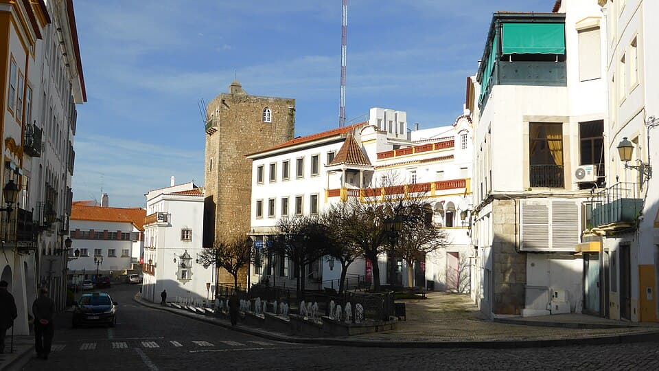 Rua do centro histórico de Elvas com torre e casario