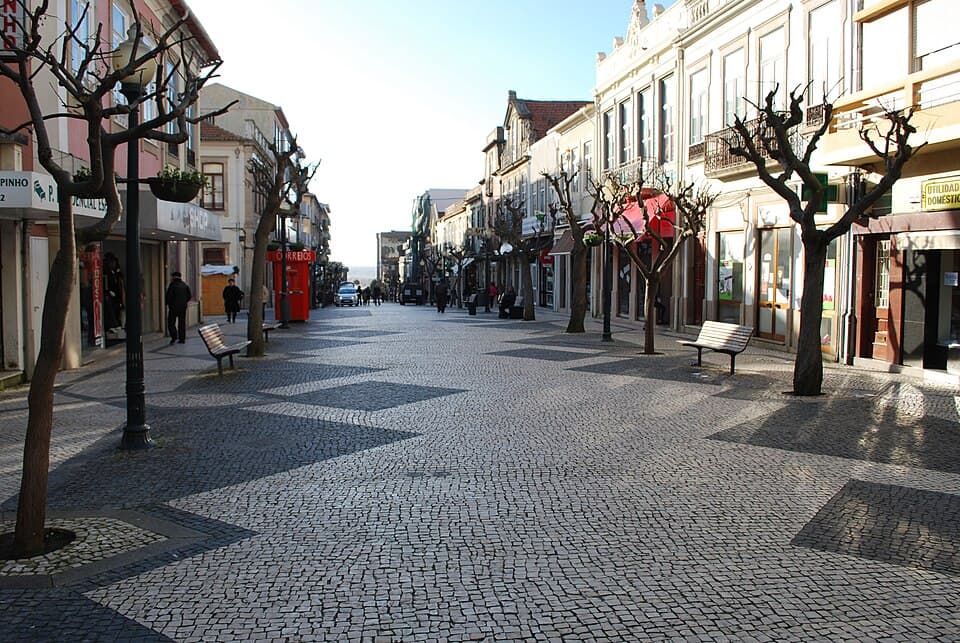 Calçada pedonal, lojas e árvores ao longo da Rua 19, em Espinho