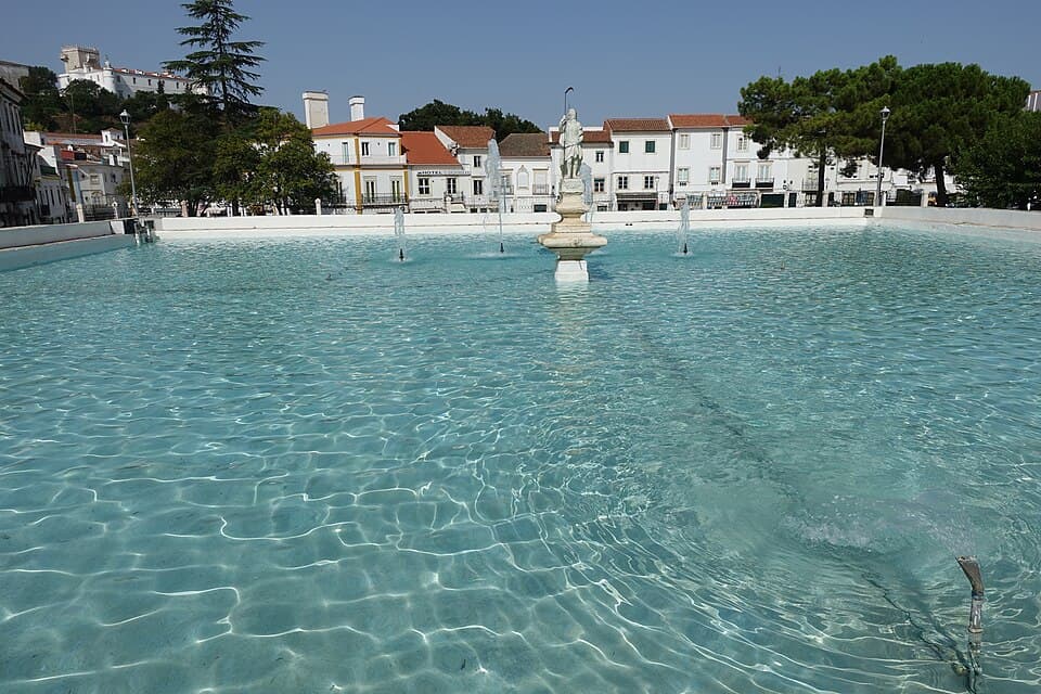 Lago do Gadanha com fonte e casario branco em Estremoz