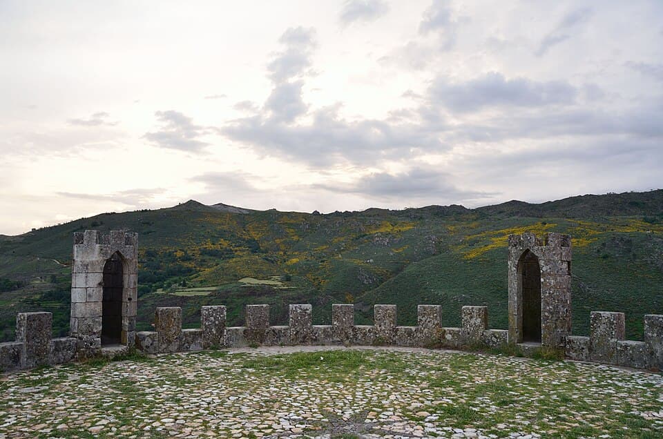 Ameias e portas do Castelo de Folgosinho diante da serra