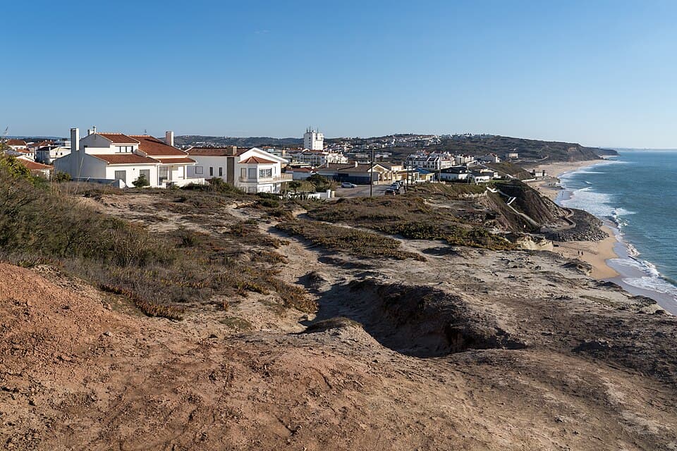 Costa e casario da Praia da Areia Branca vistos ao longo das arribas