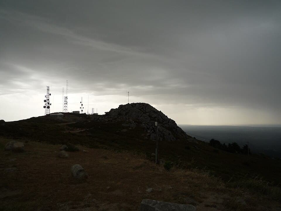 Cume rochoso e antenas na Fóia sob céu carregado