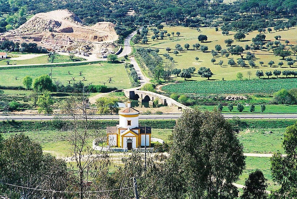 Igreja do Calvário entre campos, com a ponte sobre a Ribeira Grande ao fundo