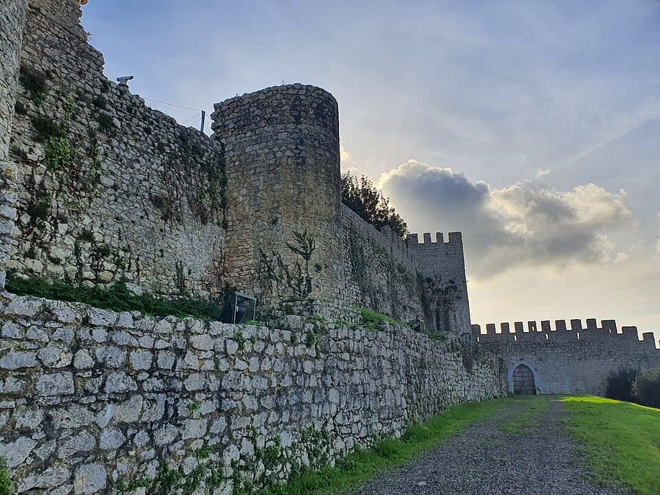 Muralhas e torre do Castelo de Montemor-o-Velho sob céu nublado