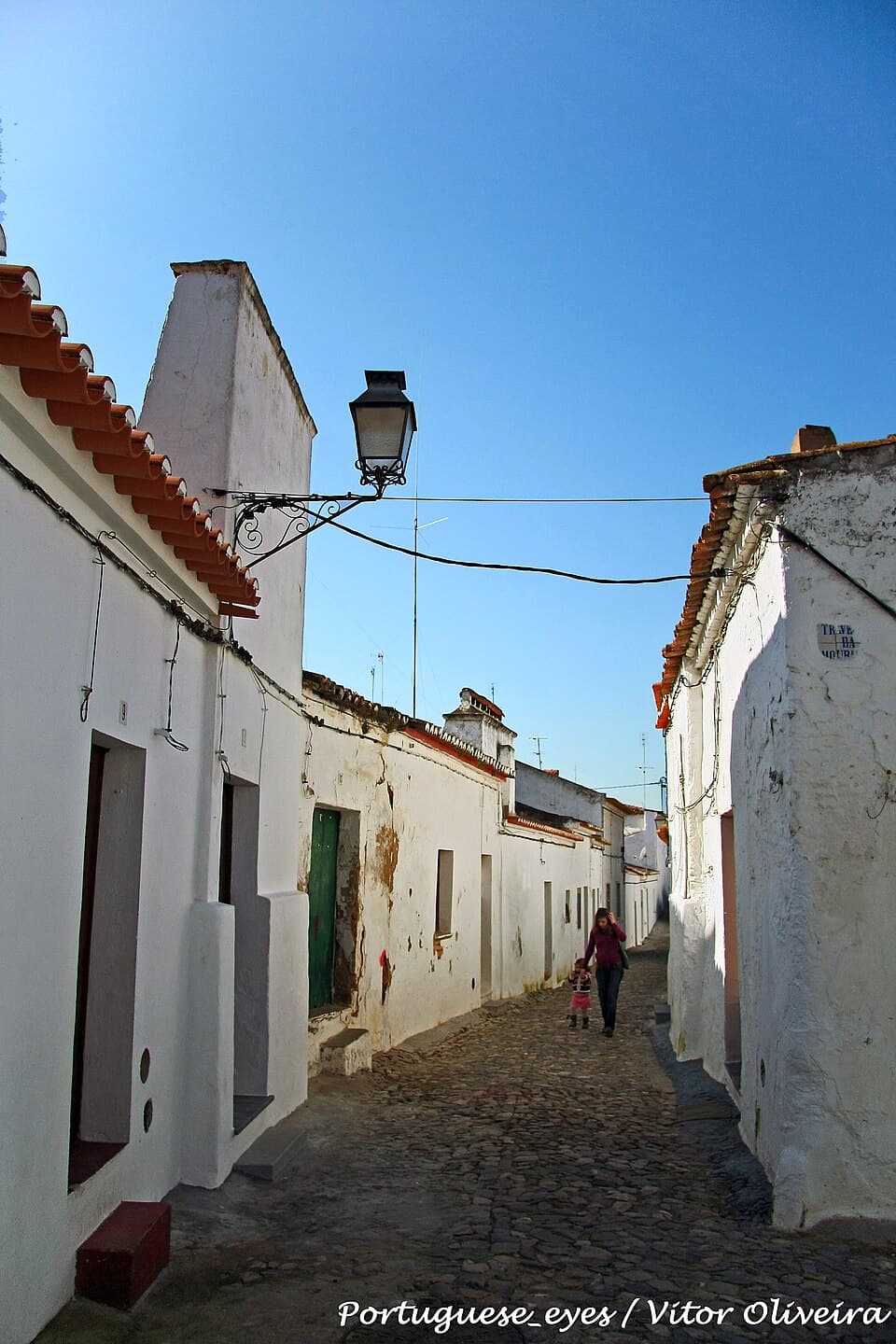 Rua estreita de casas caiadas na Mouraria de Moura