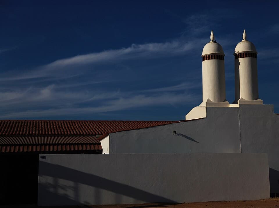 Chaminés brancas arredondadas sobre os telhados da Aldeia da Luz