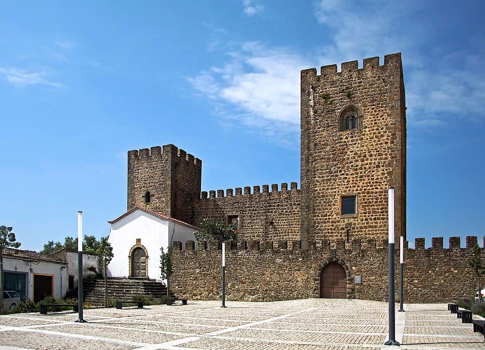 Castelo de Amieira do Tejo com torres ameadas, muralha e capela branca