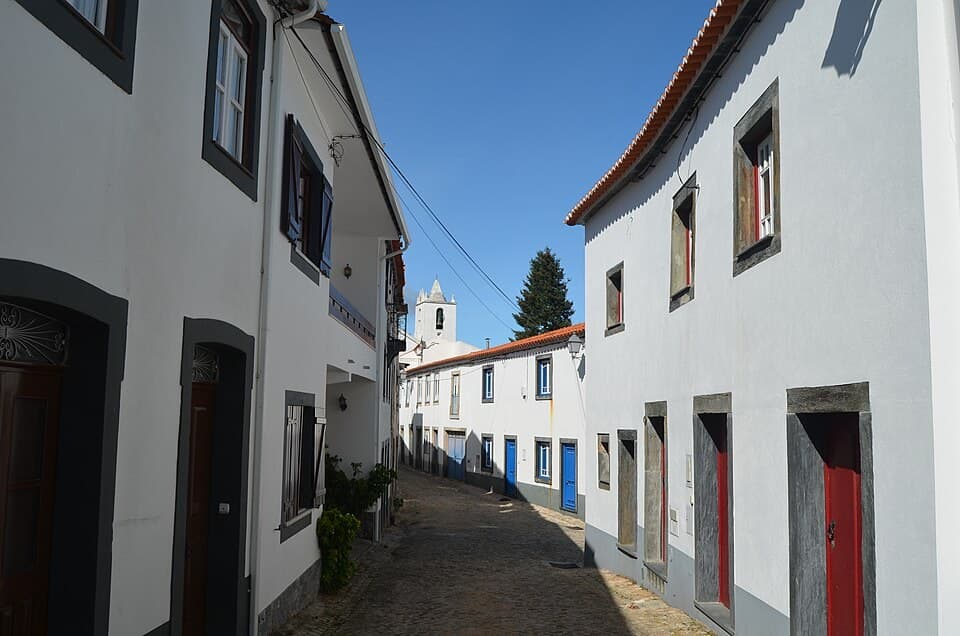 Rua calcetada e casas brancas no centro antigo de Oleiros