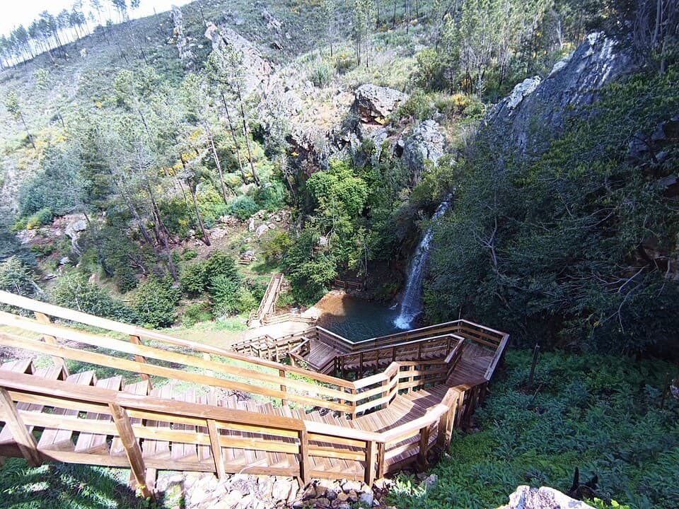 Passadiços de madeira e cascata entre vegetação no Orvalho, em Oleiros