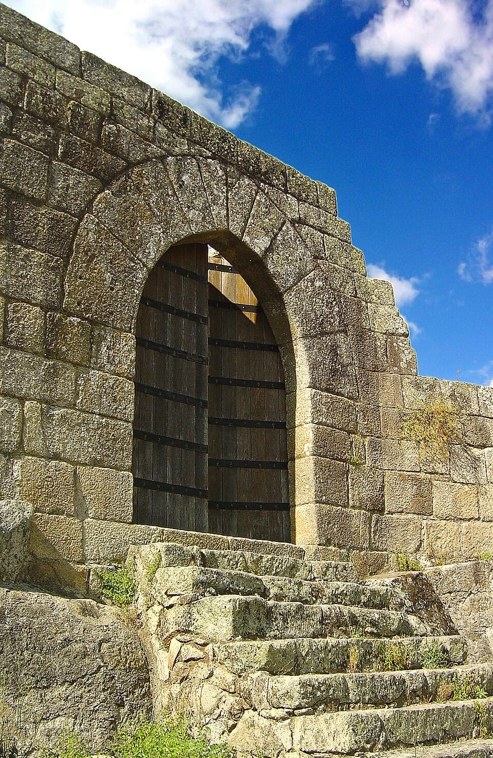Porta de arco e muralha de pedra nas ruínas do Castelo de Avô