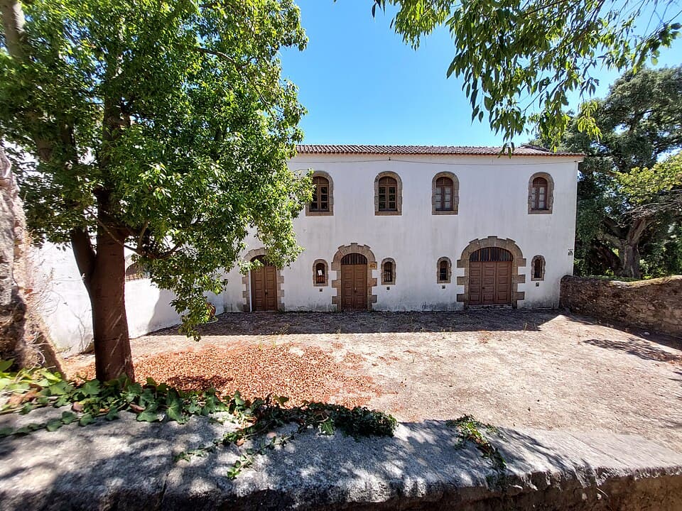 Fachada branca do Museu Pedro Cruz entre árvores