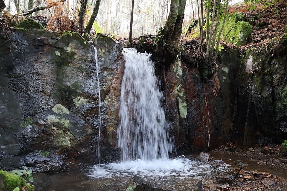 Cascatinha do Aguieiro entre rochas e arvoredo, em Quintandona