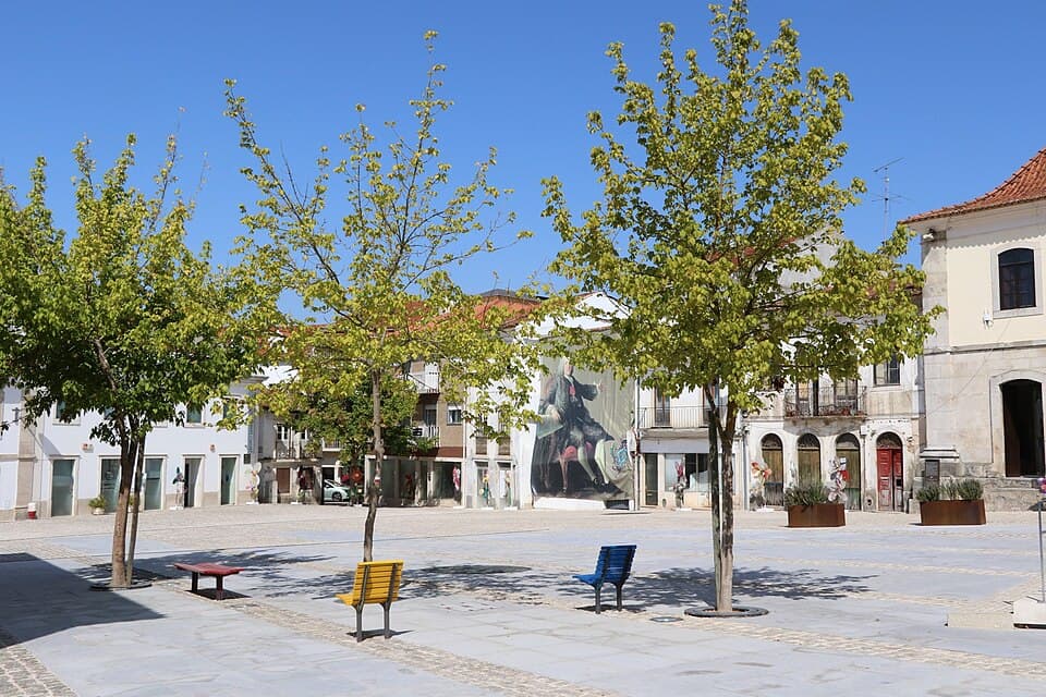 Praça Marquês de Pombal com edifícios históricos e calçada
