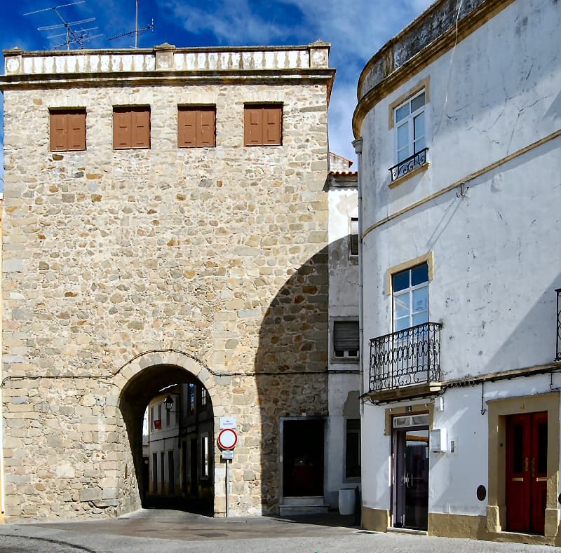 Arco de pedra da Porta de Alegrete entre o casario de Portalegre