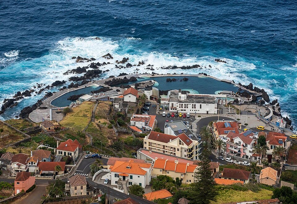 Piscinas naturais de Porto Moniz entre o oceano Atlântico e a vila