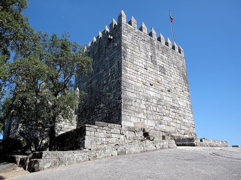 Torre de menagem e muralhas do Castelo de Lanhoso sob o céu azul