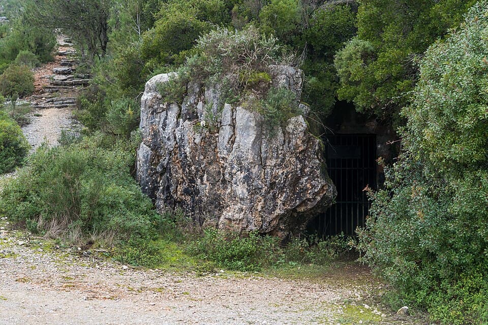 Entrada da Gruta de Alcobertas entre rochas e vegetação