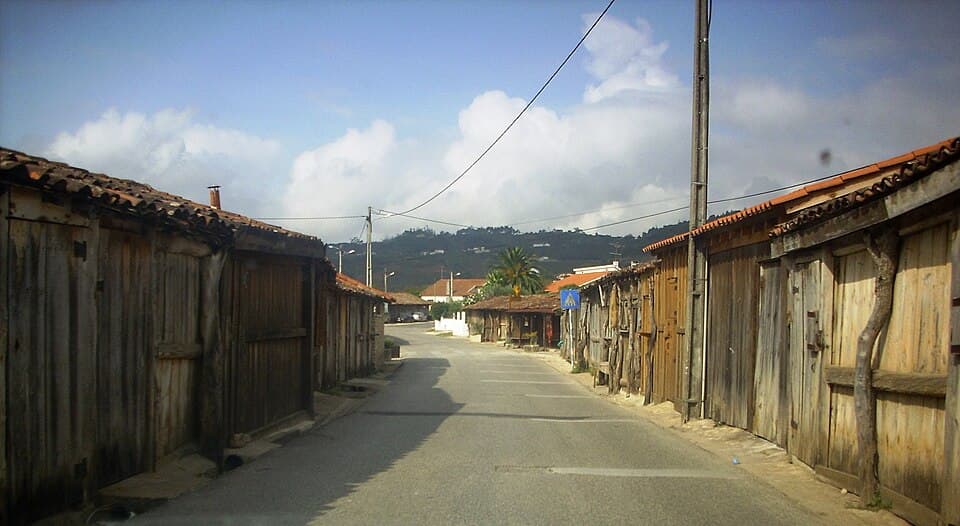 Rua ladeada por casas de madeira nas Salinas de Rio Maior