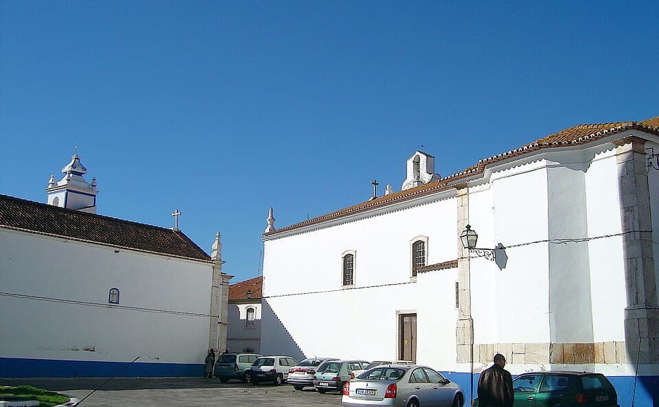 Conjunto branco da Igreja Matriz de Sousel com torres e telhados sob céu azul