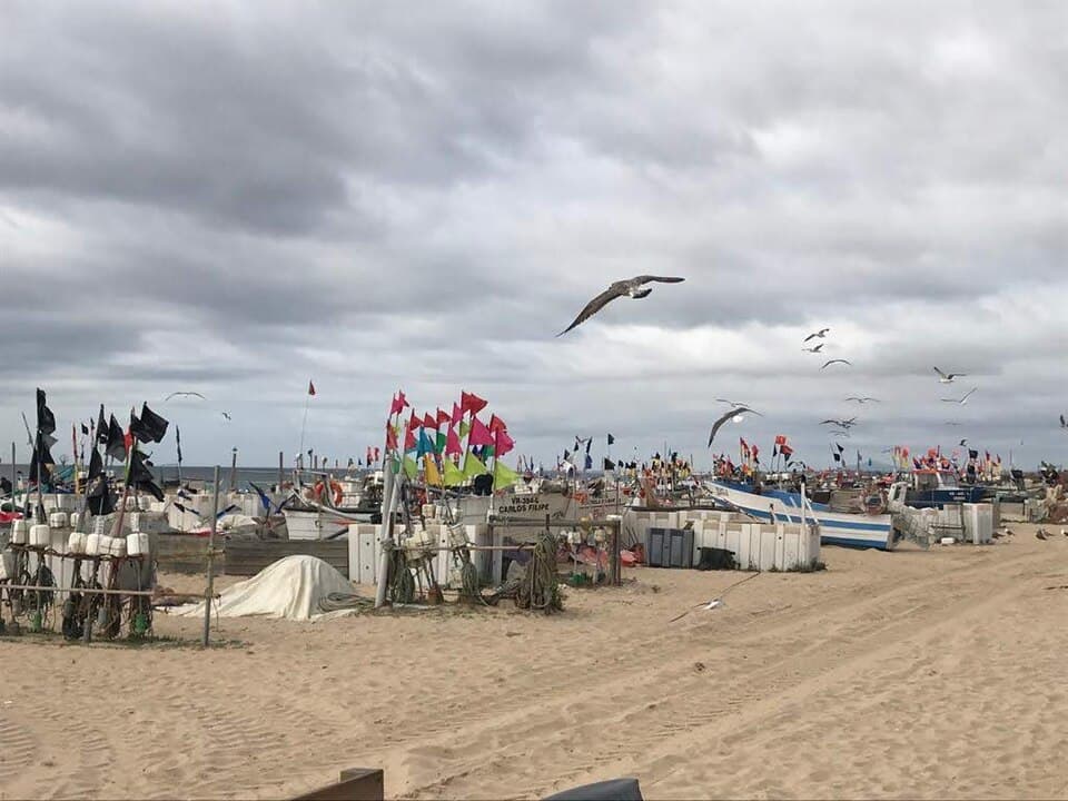 Areal da Praia de Monte Gordo com embarcações e estruturas de praia